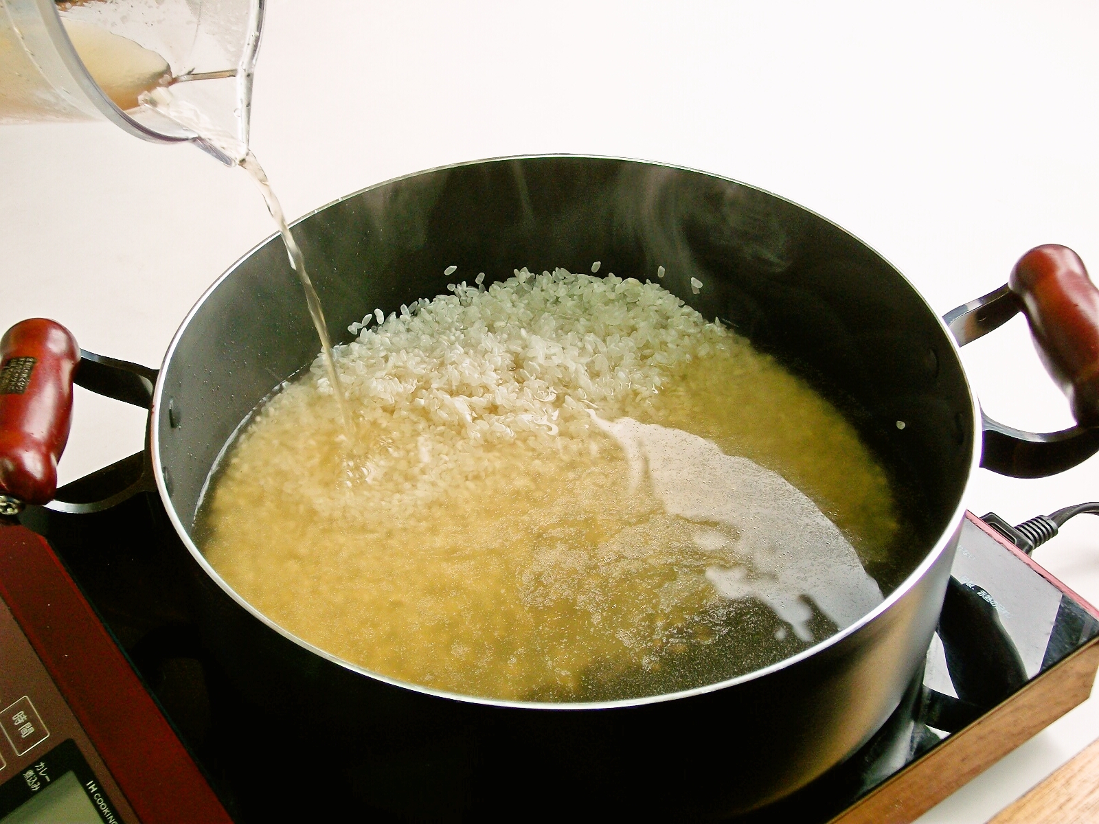 手順２：洗ったお米とコンソメスープをお鍋に入れる